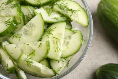 Cut cucumber with dill in glass bowl and fresh vegetables on table, flat lay