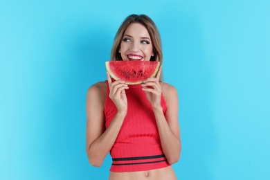 Pretty young woman with juicy watermelon on color background