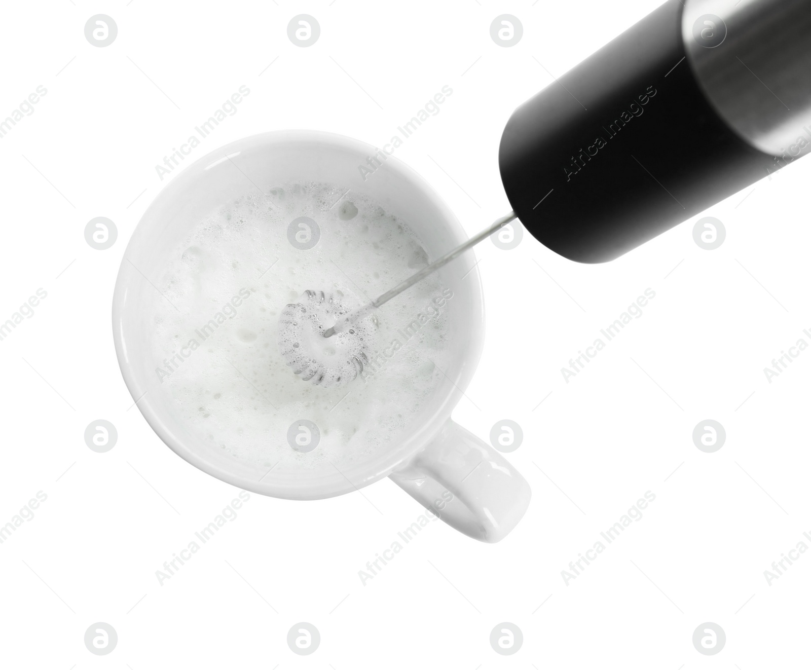 Photo of Whisking milk in cup with mini mixer (frother wand) isolated on white, top view