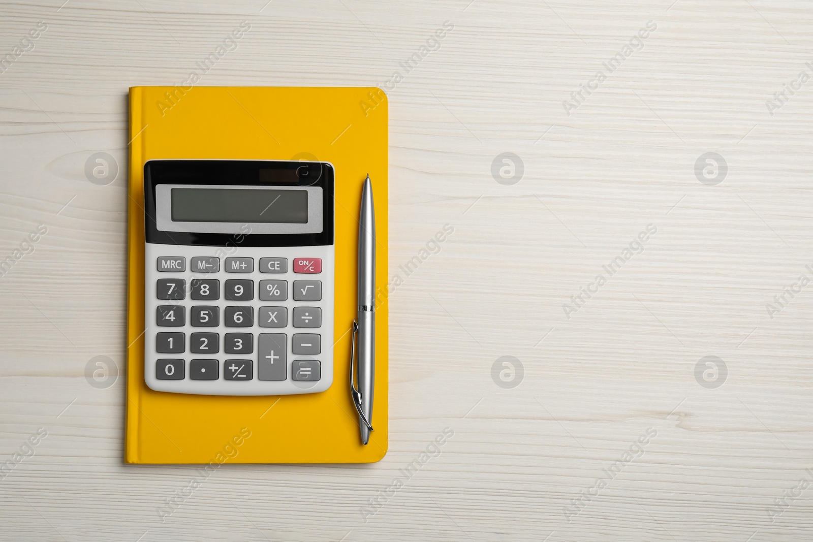 Photo of Calculator, notebook and pen on white wooden table, top view with space for text