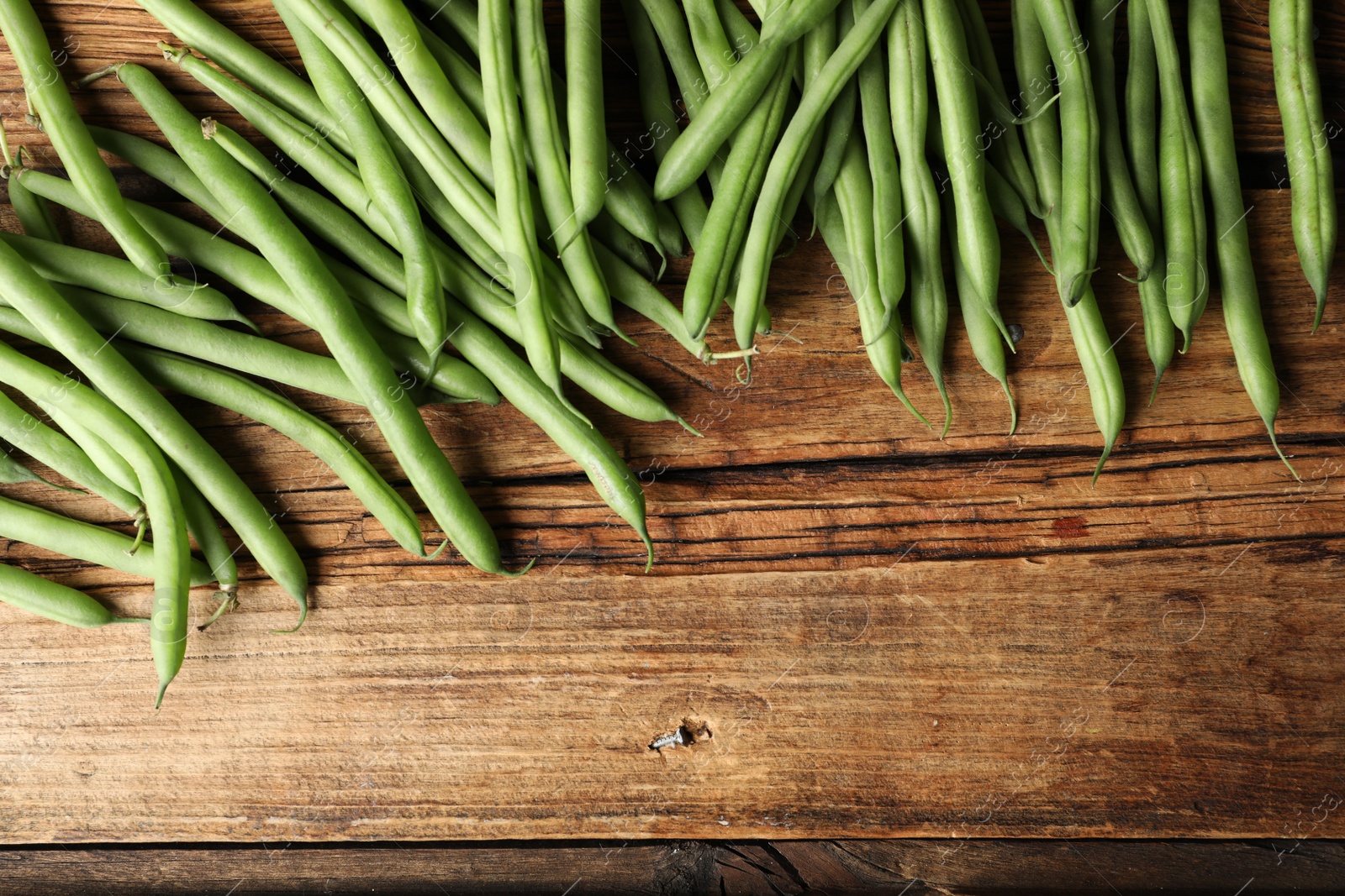 Photo of Fresh green beans on wooden table, flat lay. Space for text