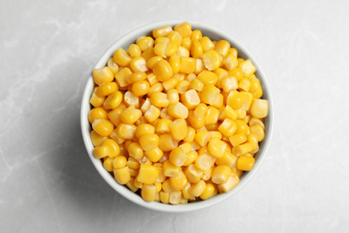 Delicious canned corn in bowl on marble table, top view