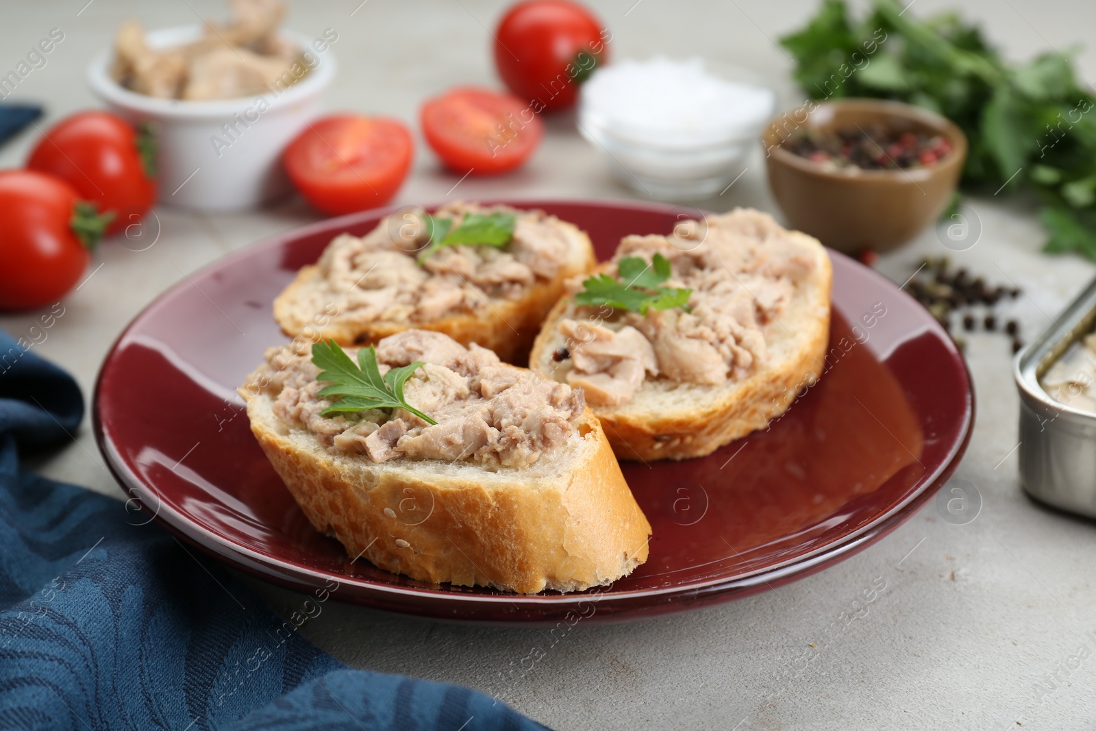 Photo of Tasty sandwiches with cod liver and different products on light grey table