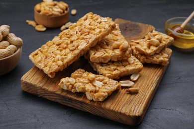 Photo of Delicious peanut bars (kozinaki) and ingredients on black table