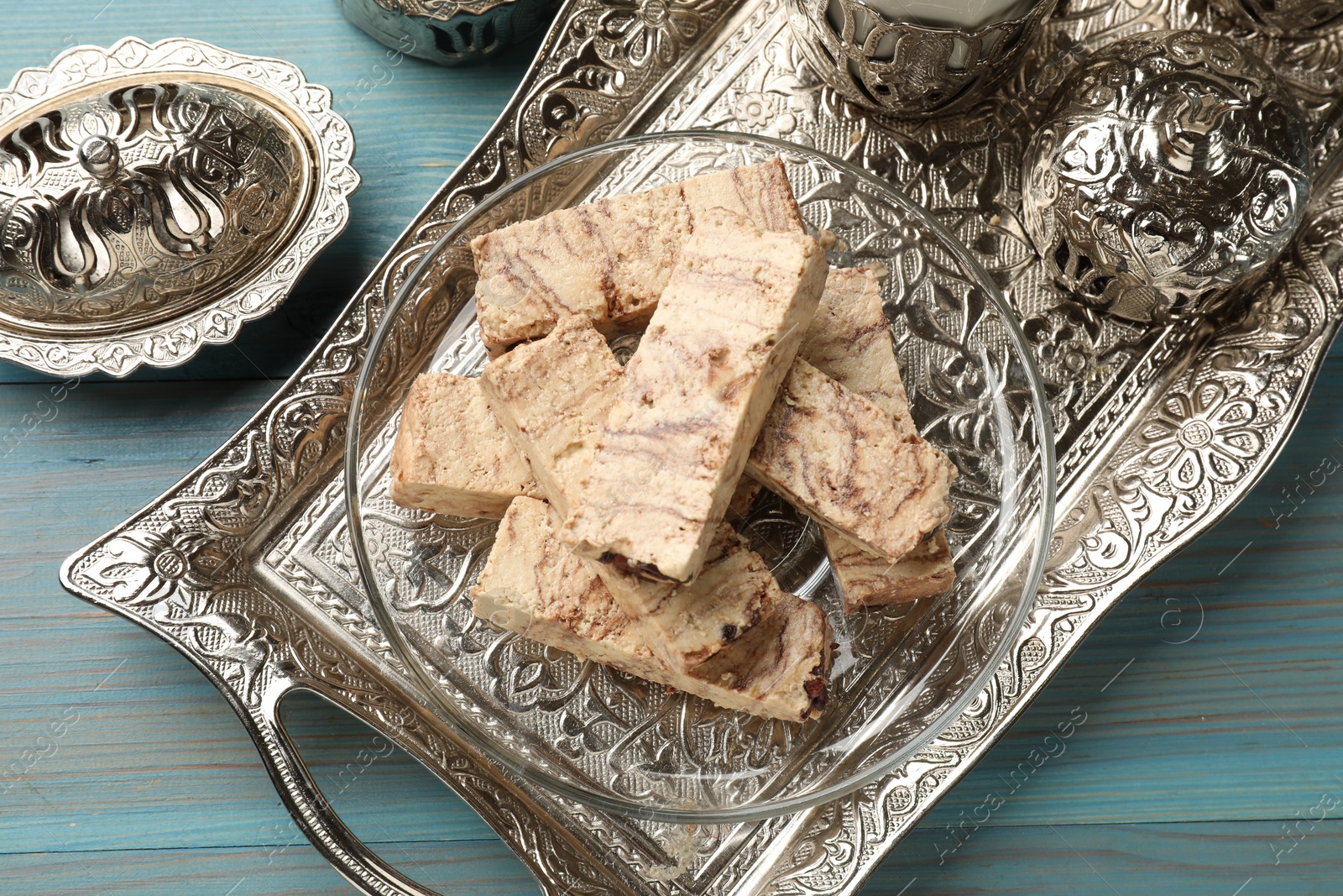 Photo of Tasty chocolate halva served on light blue wooden table, top view