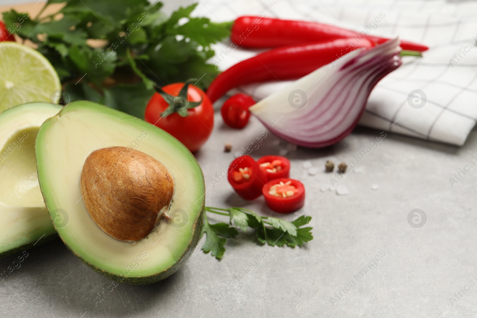 Photo of Fresh ingredients for guacamole on light grey table