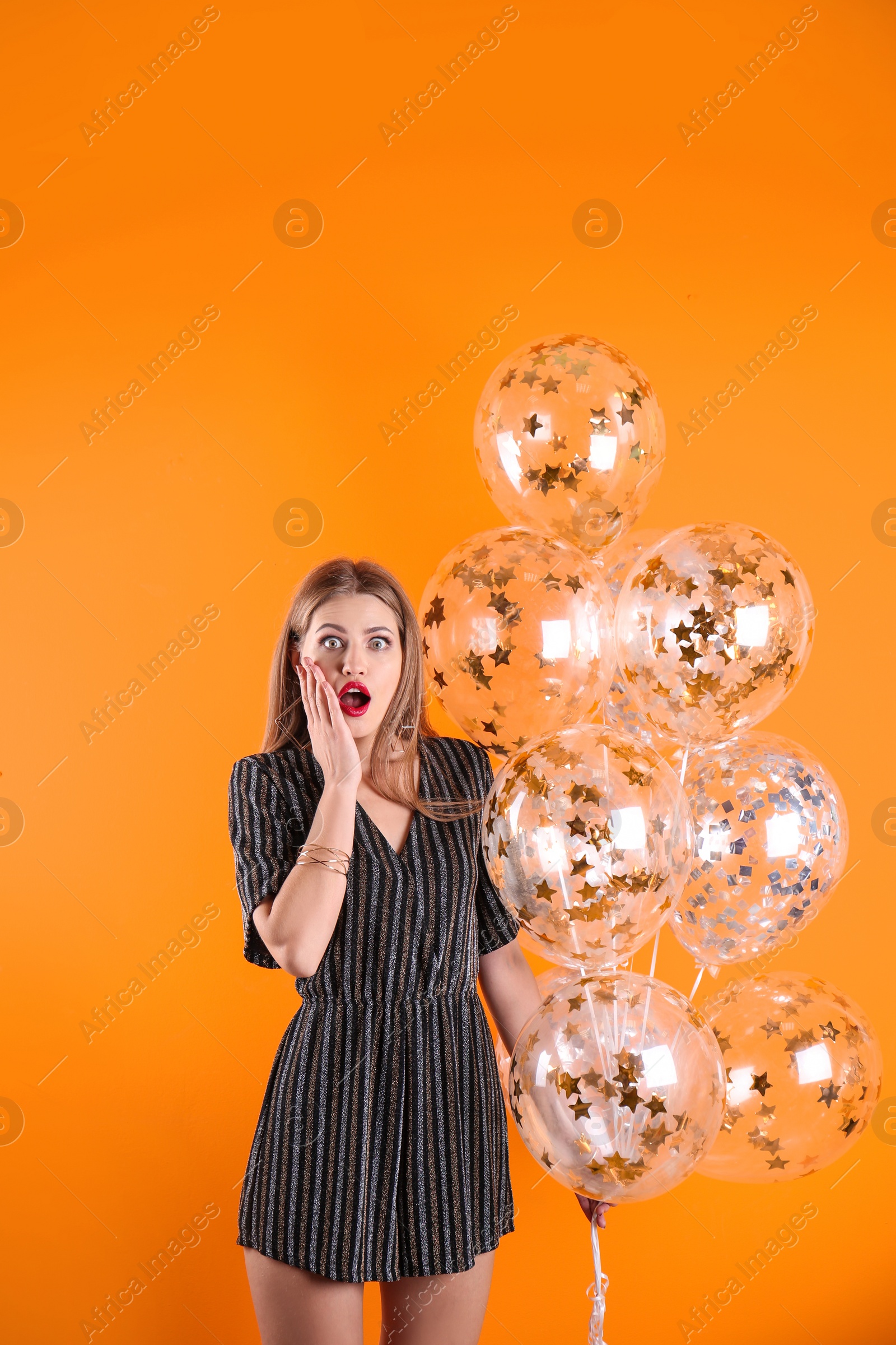 Photo of Young woman with air balloons on color background