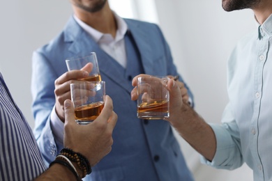 Group of friends drinking whiskey together indoors, closeup