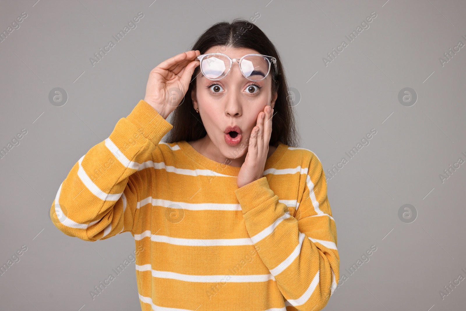 Photo of Portrait of surprised woman on grey background