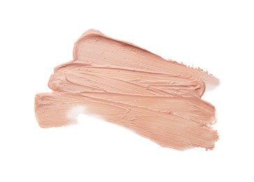 Photo of Strokes of pink color correcting concealer on white background, top view