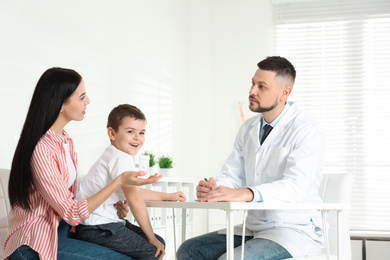 Photo of Little boy with mother visiting orthopedist at clinic