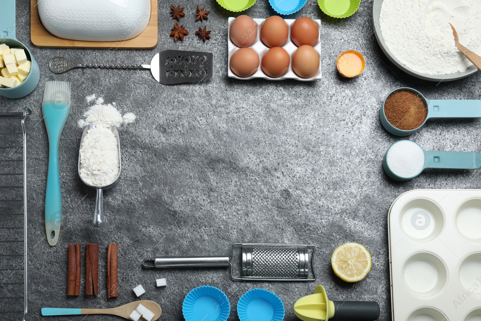 Photo of Frame of cooking utensils and ingredients on grey table, flat lay. Space for text