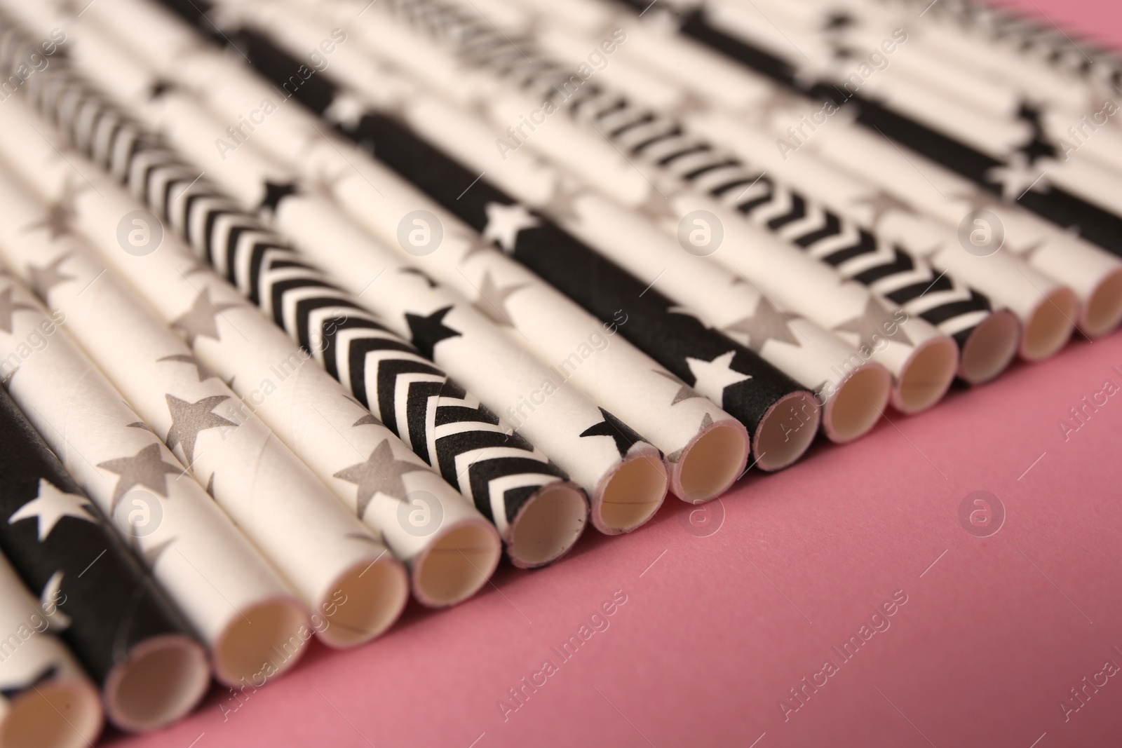 Photo of Many paper drinking straws on pink background, closeup