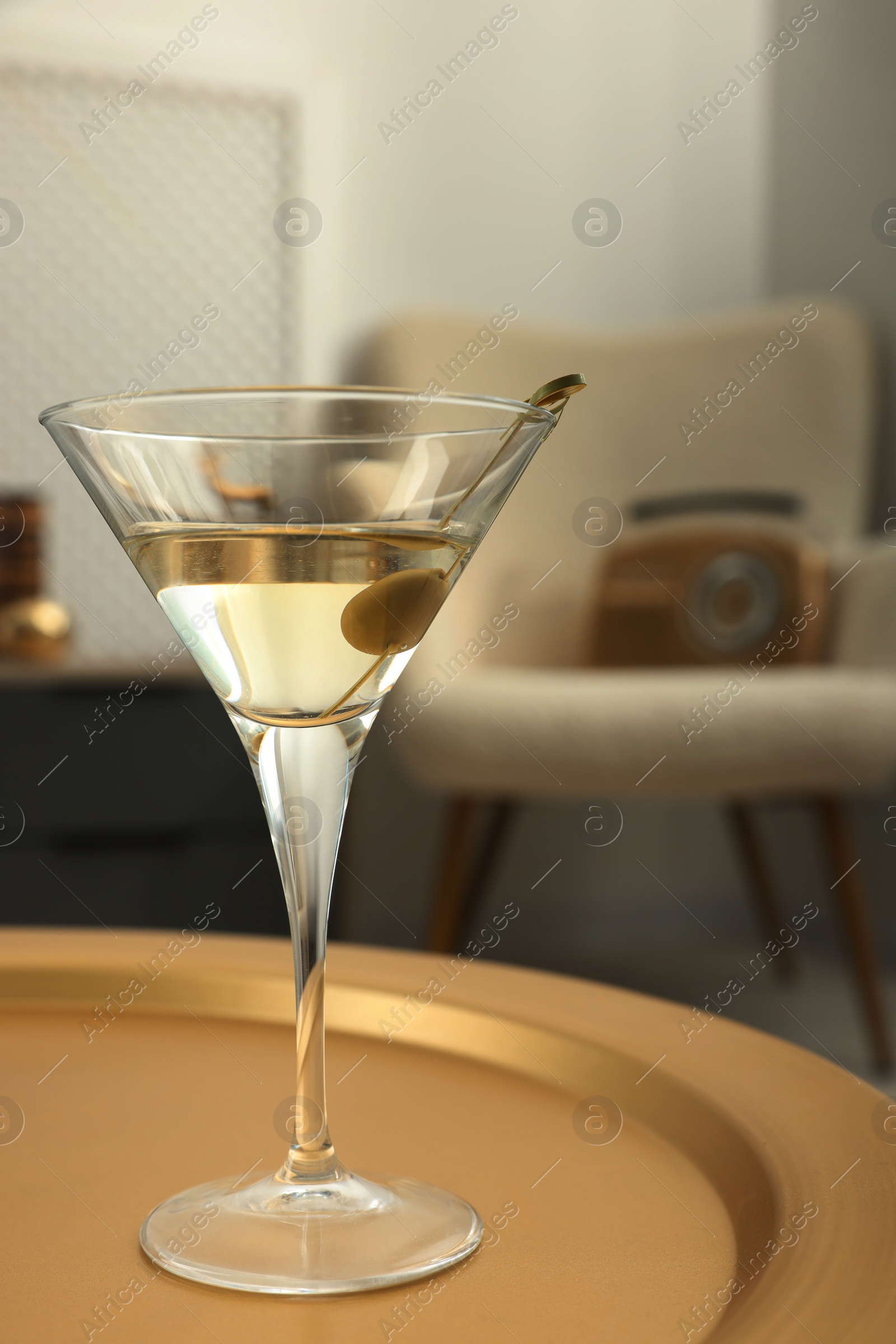 Photo of Martini cocktail with olive on table in room. Relax at home