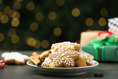 Photo of Decorated cookies on grey table against blurred Christmas lights