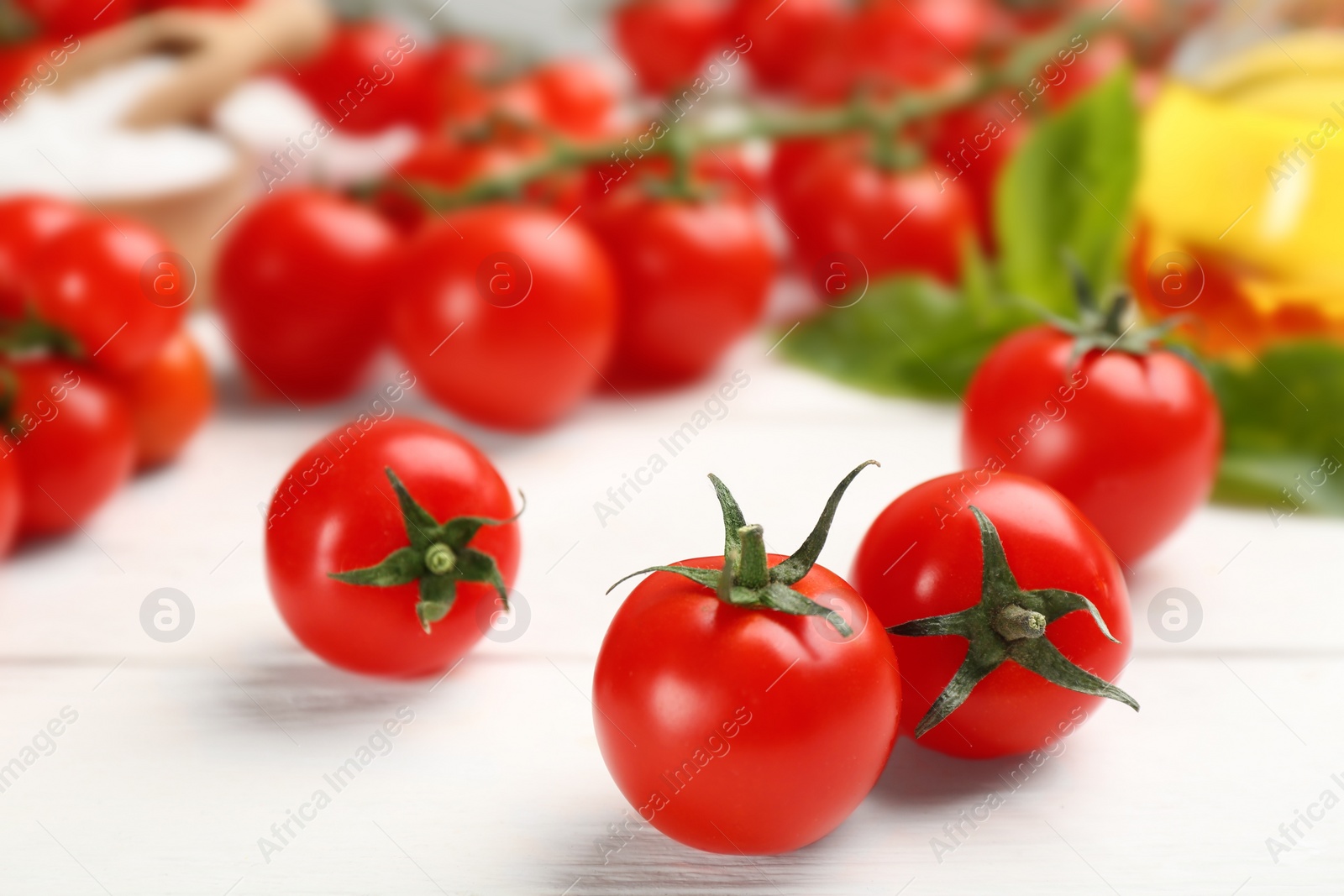 Photo of Fresh ripe cherry tomatoes on white wooden table, closeup