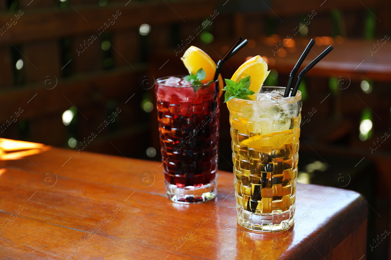 Photo of Glasses of delicious cocktails with ice on table