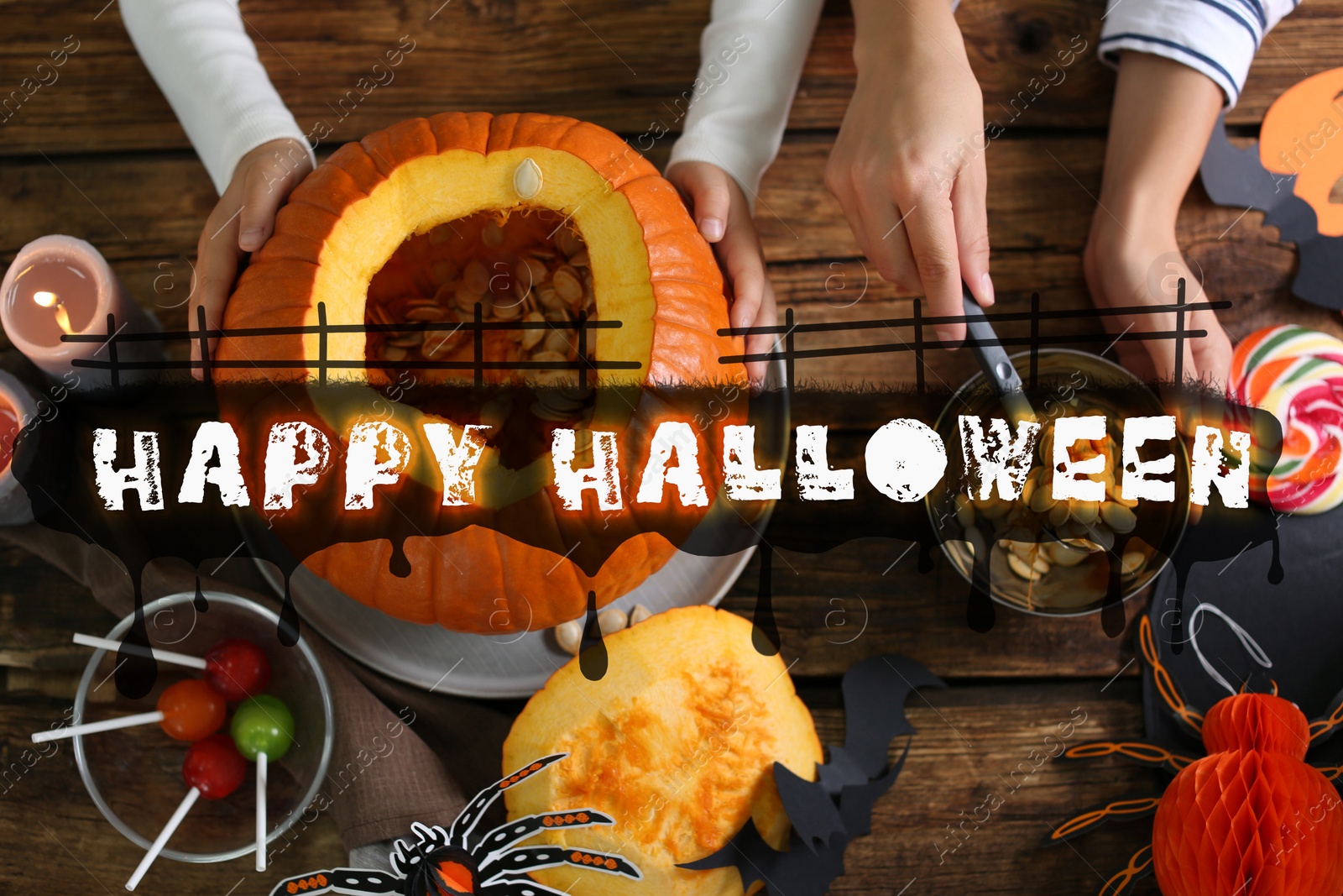 Image of Happy Halloween. Mother and daughter making pumpkin jack o'lantern at wooden table, top view