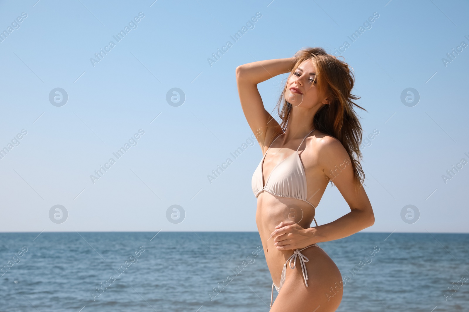 Photo of Attractive woman with perfect body in bikini near sea