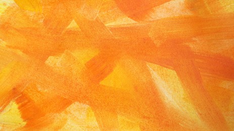 Photo of Orange paint strokes drawn with brush as background, top view