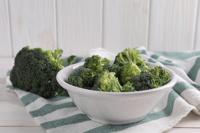 Photo of Fresh raw broccoli on white wooden table, space for text