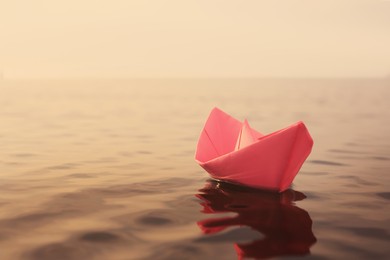Image of Pink paper boat floating on river. Retro photo effect