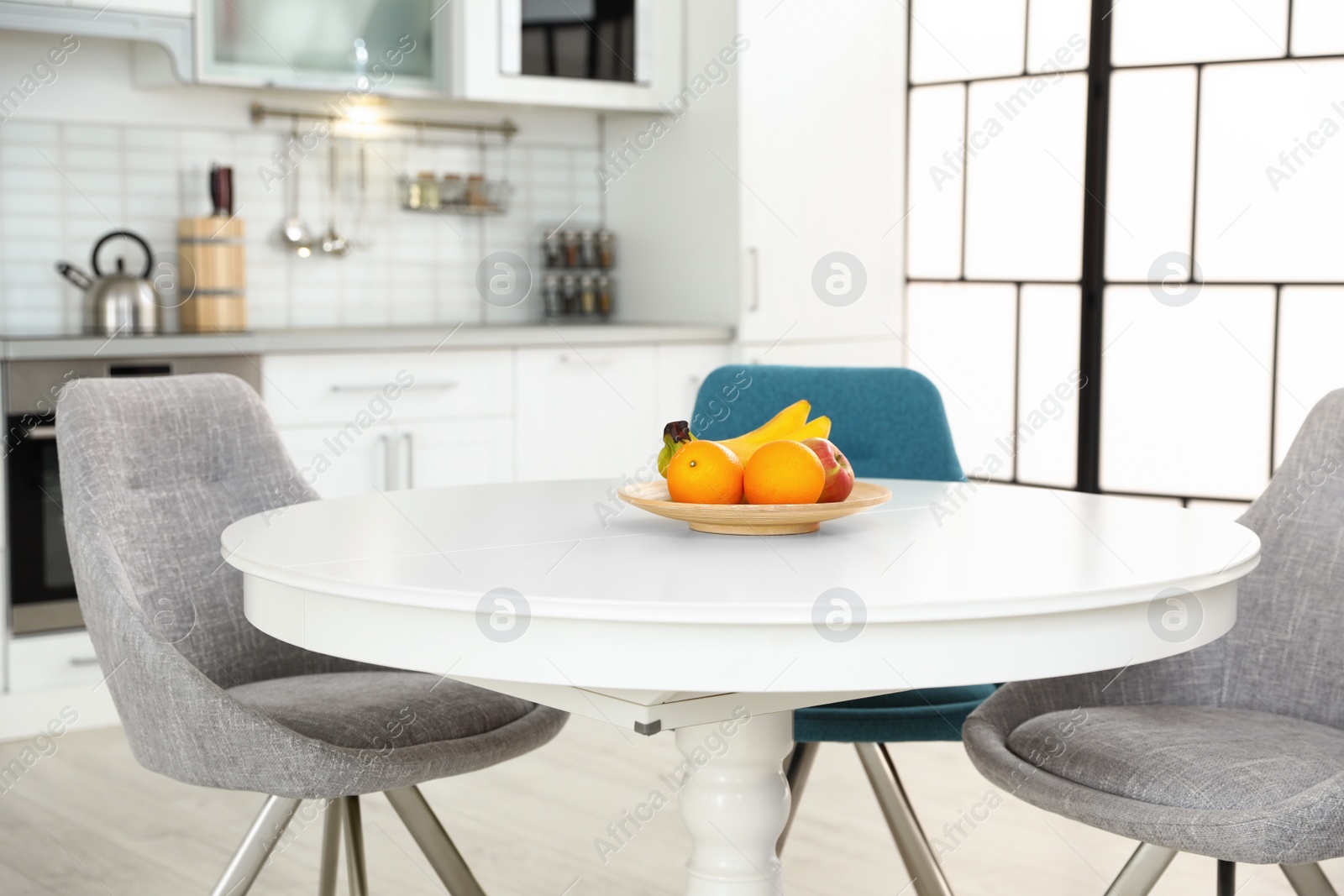 Photo of Stylish kitchen interior with dining table and chairs