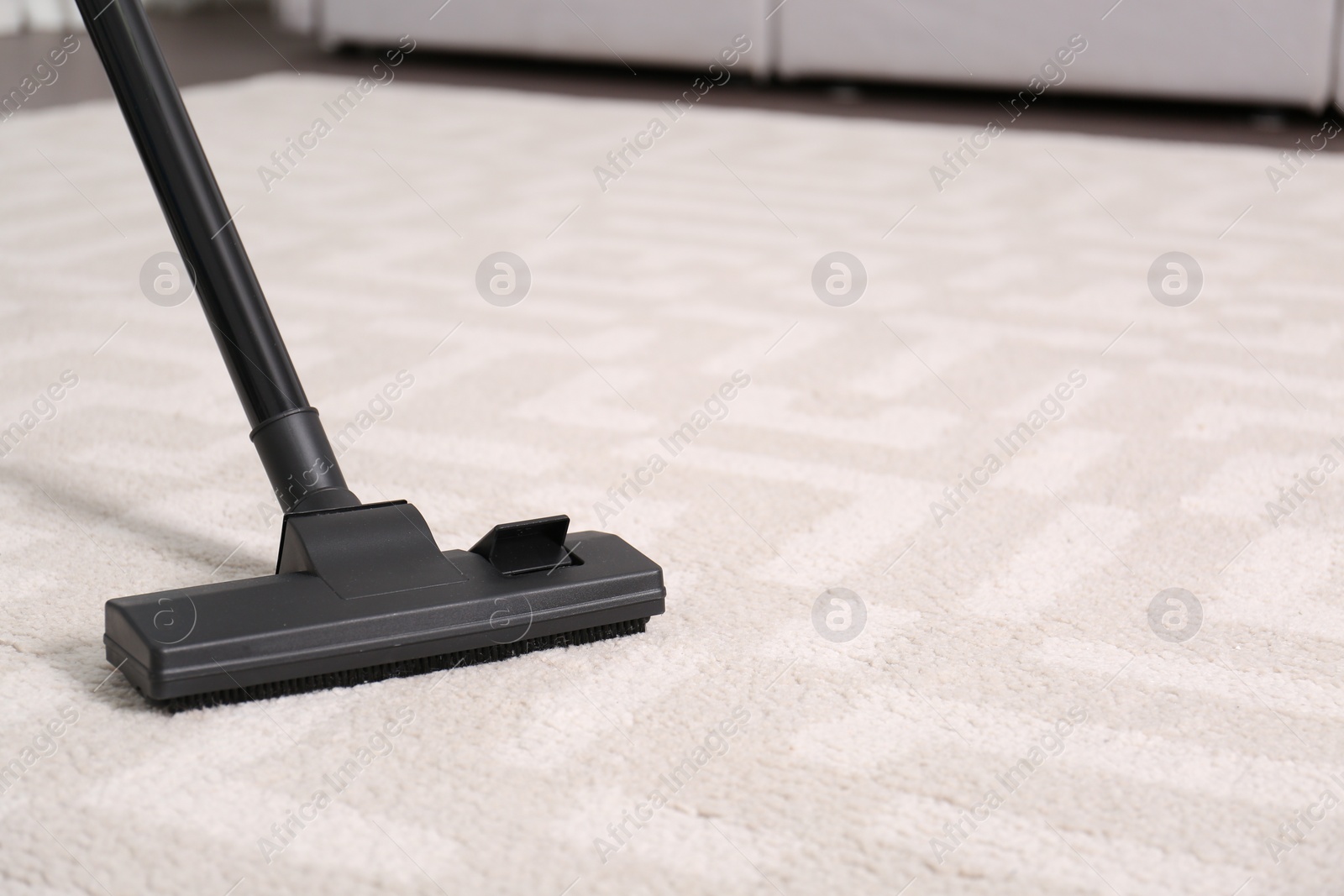 Photo of Hoovering floor with modern vacuum cleaner, closeup. Space for text