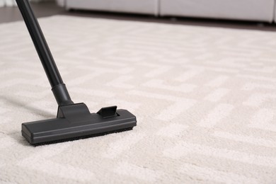 Hoovering floor with modern vacuum cleaner, closeup. Space for text