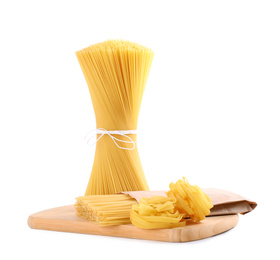 Photo of Wooden board with spaghetti and tagliatelle pasta isolated on white