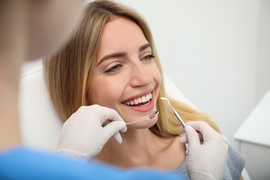 Photo of Doctor examining patient's teeth in clinic, closeup. Cosmetic dentistry