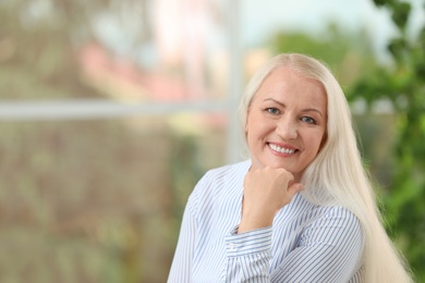 Photo of Portrait of beautiful older woman against blurred background with space for text