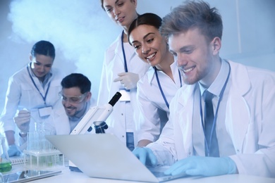 Photo of Group of scientists working in modern chemistry laboratory