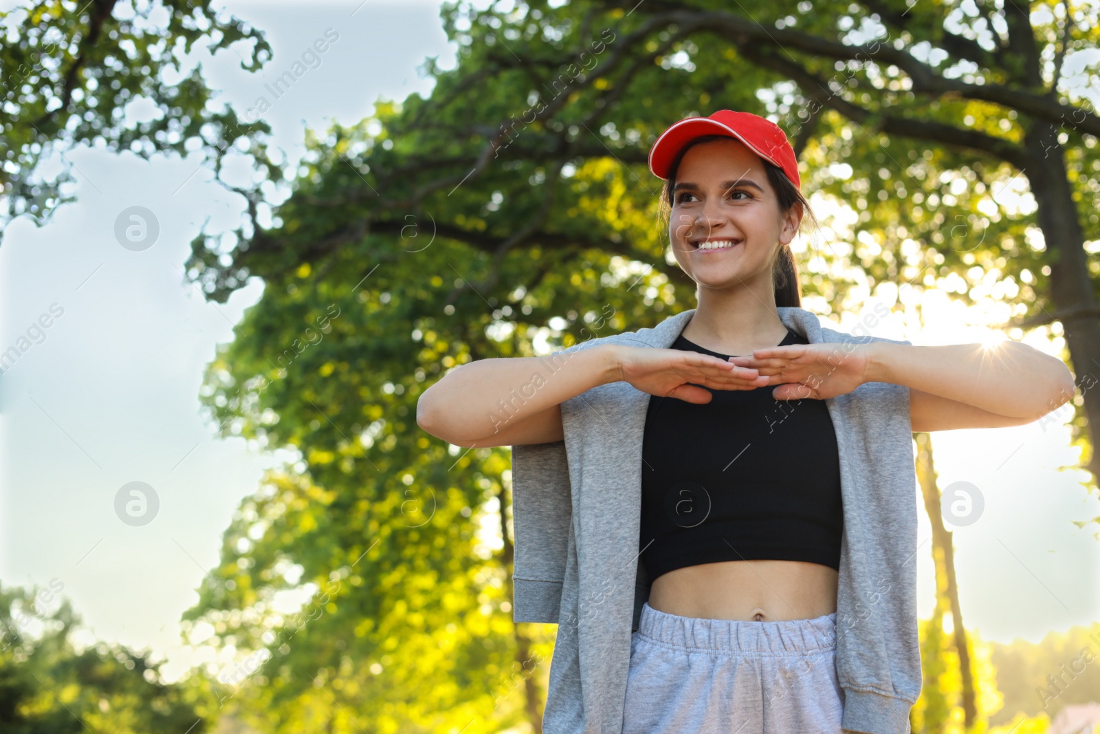 Photo of Young woman doing morning exercise in park. Space for text