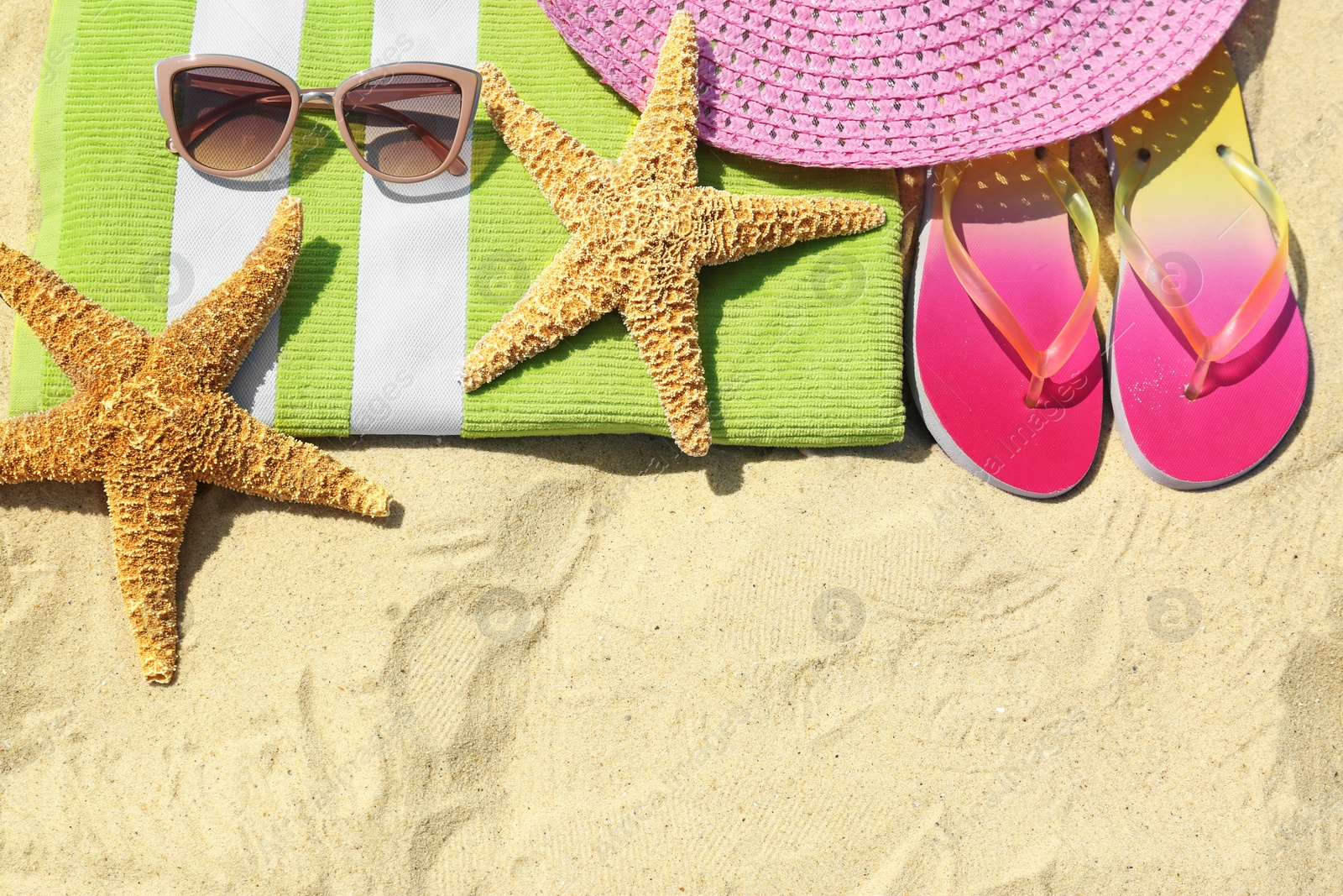 Photo of Flat lay composition with beach accessories on sand. Space for text