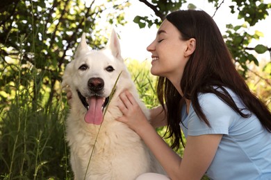 Photo of Teenage girl with her white Swiss Shepherd dog in park