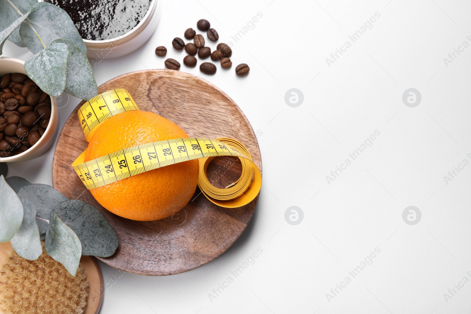 Photo of Flat lay composition with orange and measuring tape on white background, space for text. Cellulite treatment