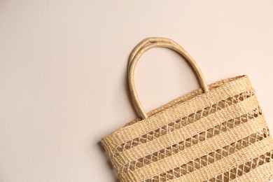 Elegant woman's straw bag on beige background, top view. Space for text