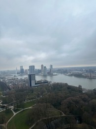 Picturesque view of city with modern buildings and park on cloudy day