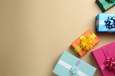 Photo of Many colorful gift boxes on beige background, flat lay. Space for text