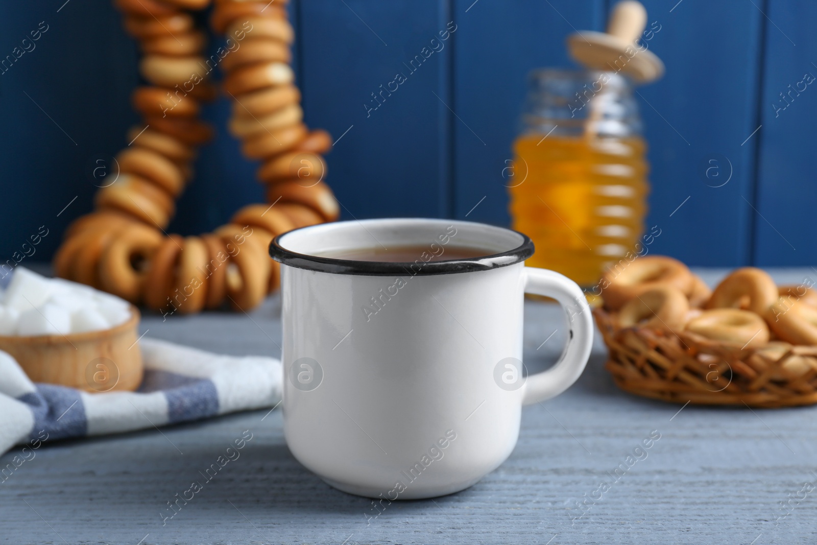 Photo of Delicious ring shaped Sushki (dry bagels), focus on mug of tea and samovar