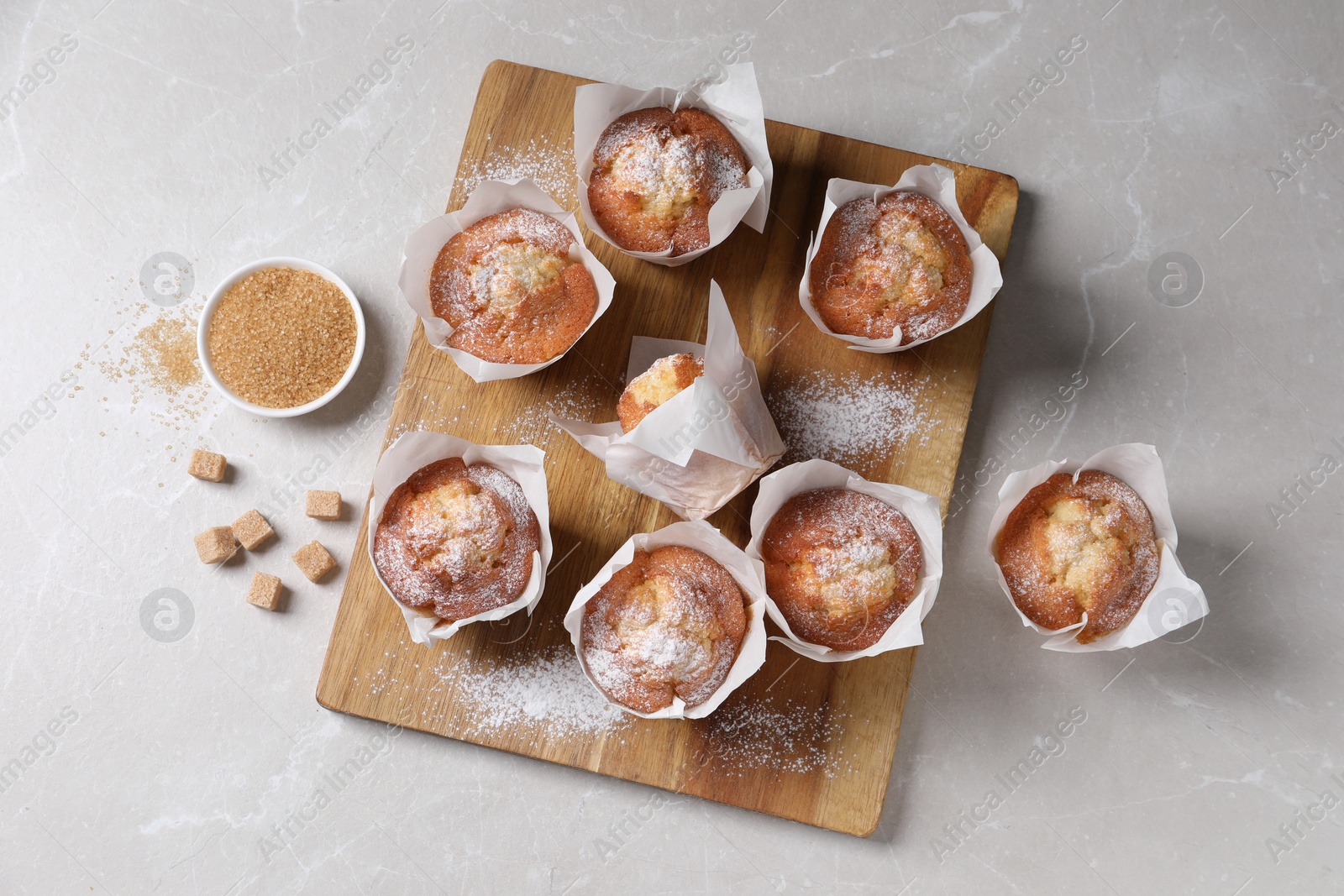 Photo of Delicious muffins on light table, flat lay