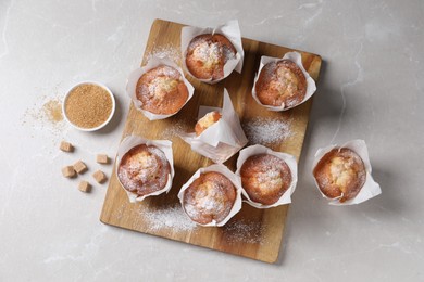 Photo of Delicious muffins on light table, flat lay