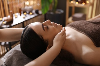 Photo of Spa therapy. Beautiful young woman lying on table during massage in salon