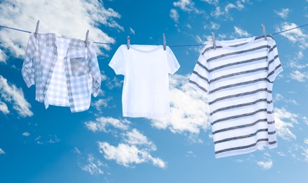 Image of Different clothes drying on washing line against sky