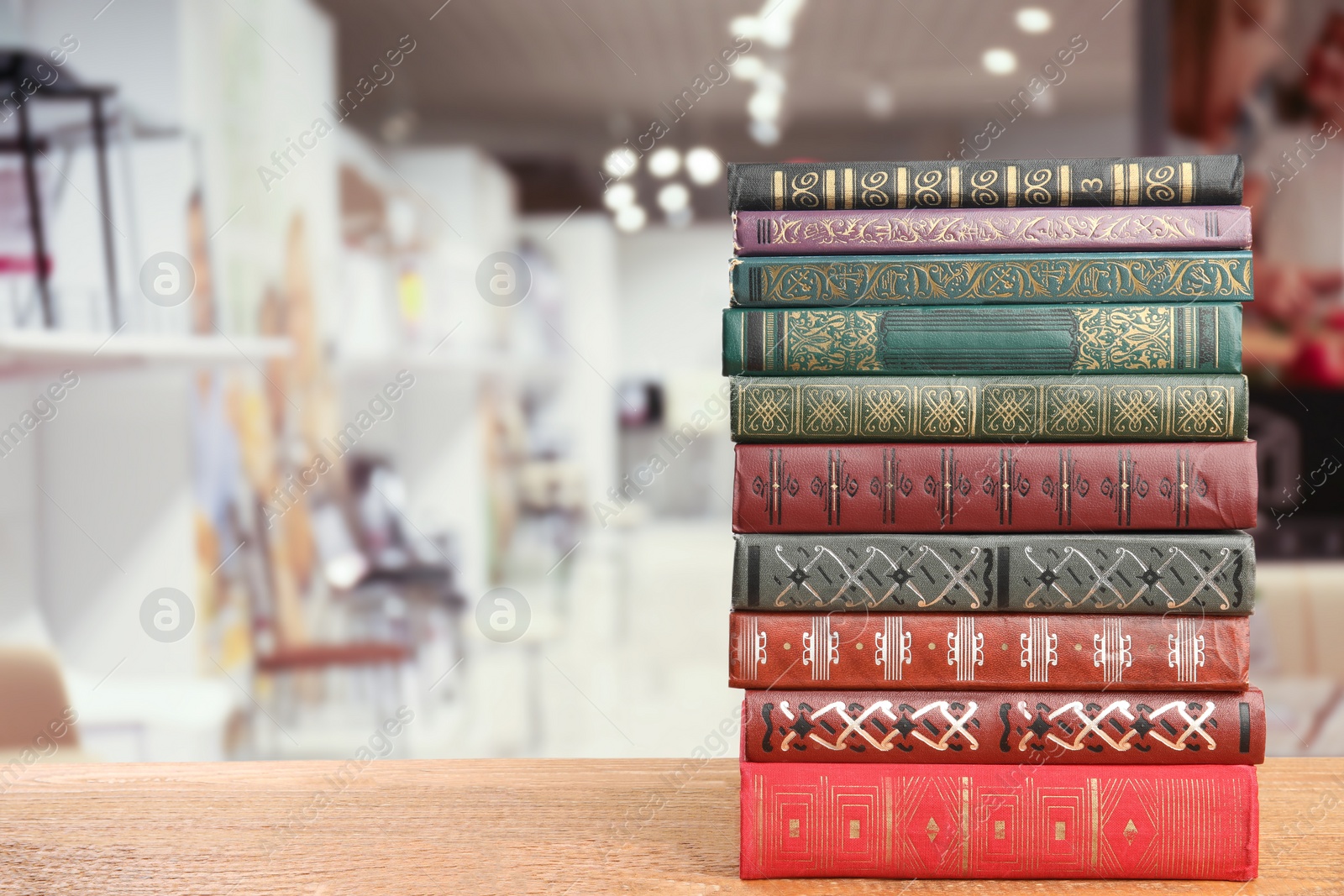 Image of Collection of different books on wooden table against blurred background, space for text