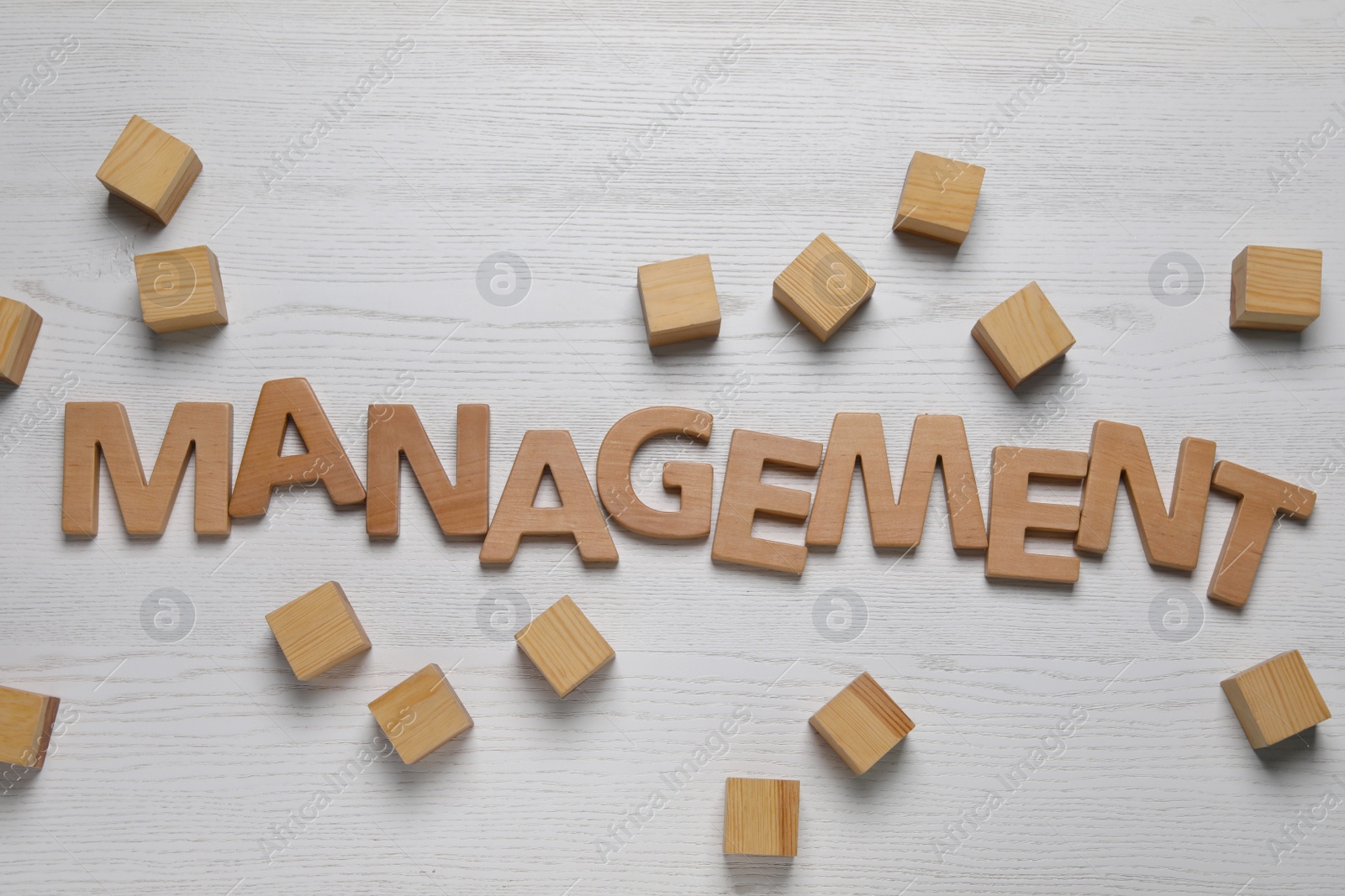 Photo of Word Management made of letters near cubes on white wooden background, flat lay