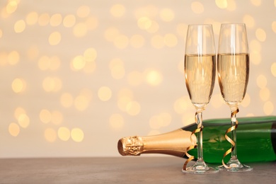 Photo of New year composition with champagne and space for text against blurred Christmas lights