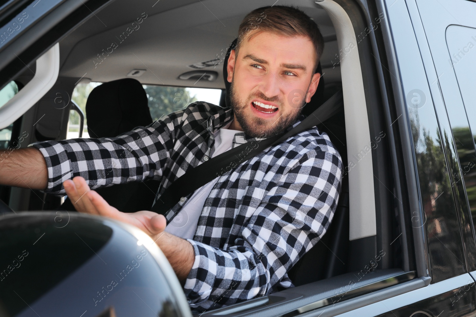 Photo of Emotional man in car. Aggressive driving behavior