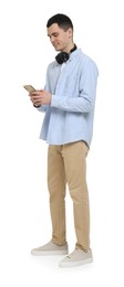 Young man with headphones using mobile phone on white background